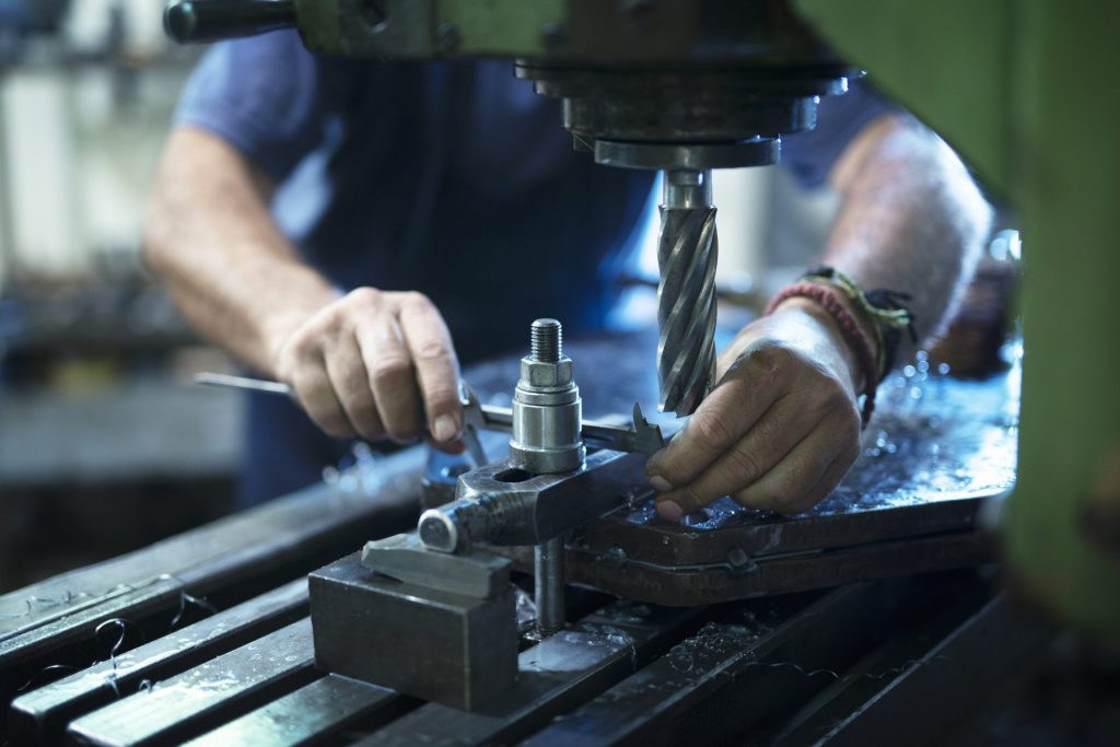 worker-operating-industrial-machine-in-metal-workshop